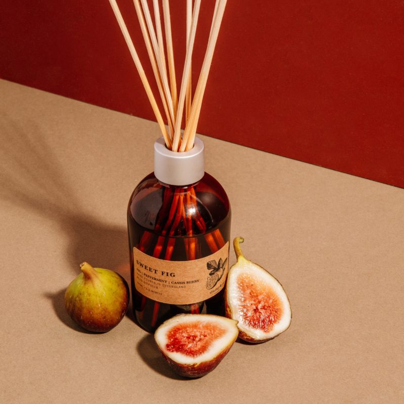 Sweet Fig Diffuser in Amber bottle surrounded by natural fresh figs